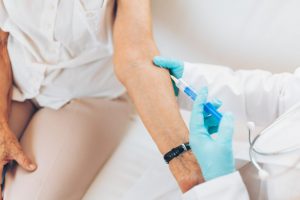 Doctor administering a vaccine on an elderly patient