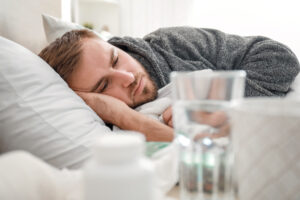 Man ill with flu lying in bed